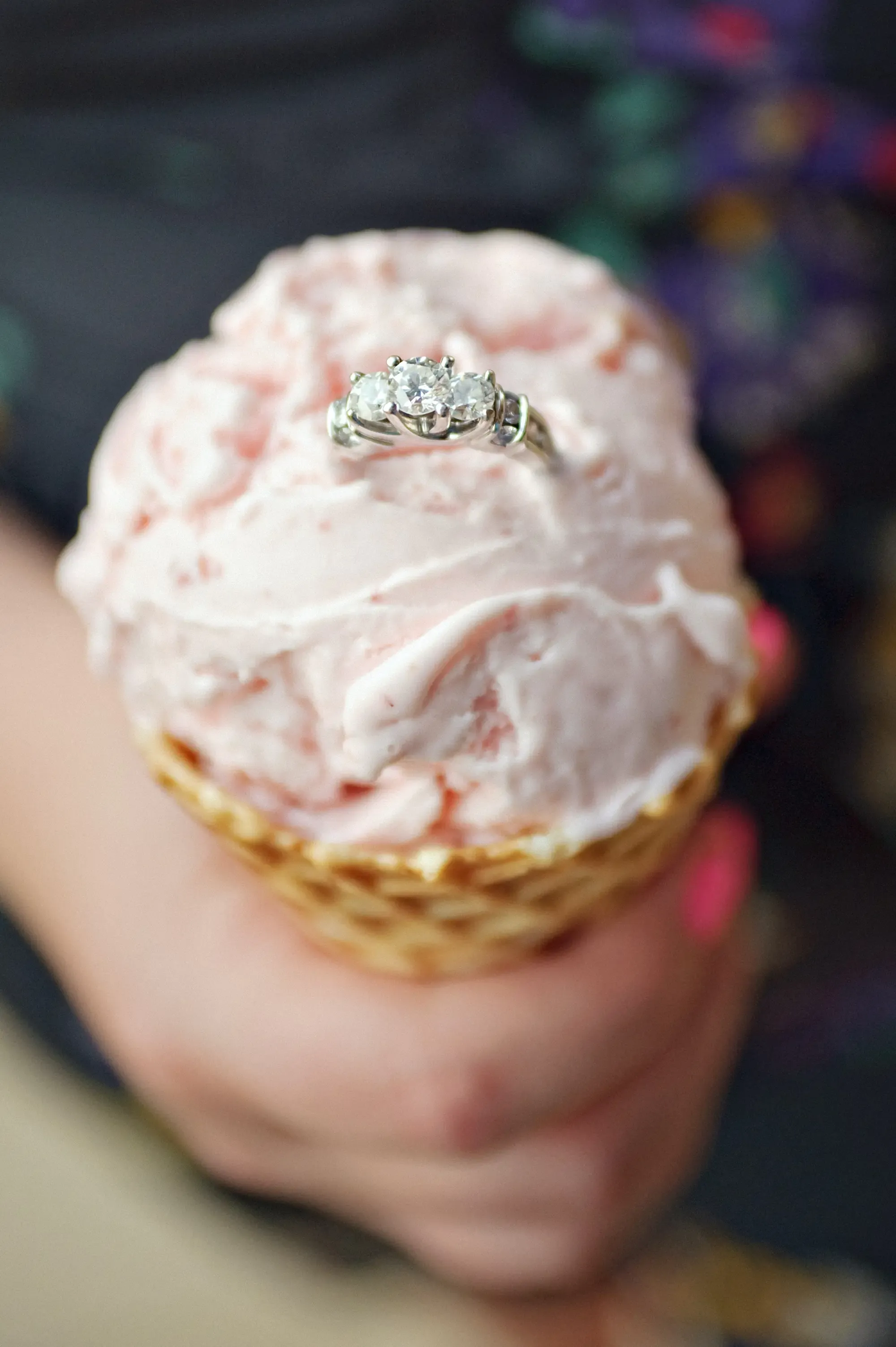 A multi stone diamond ring is stuck in the top of an ice cream cone.