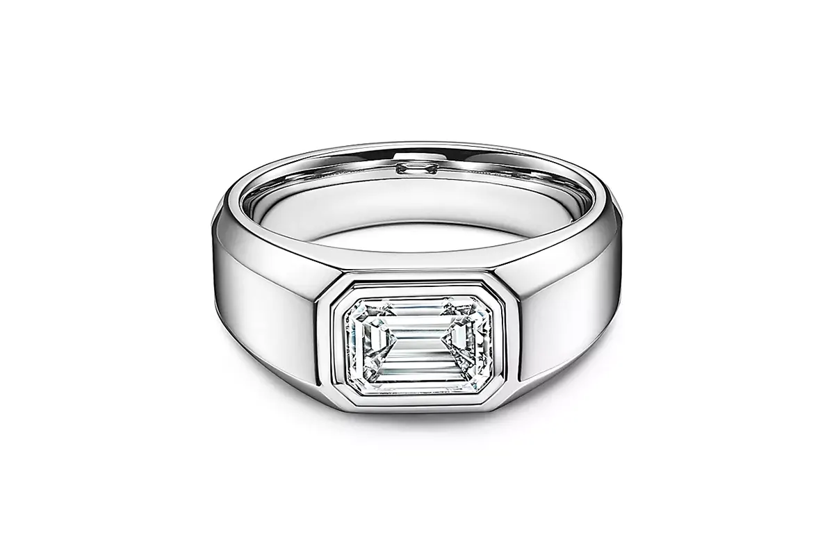 A men's engagement ring from Tiffany &Co. featuring an emerald cut diamond set in platinum.